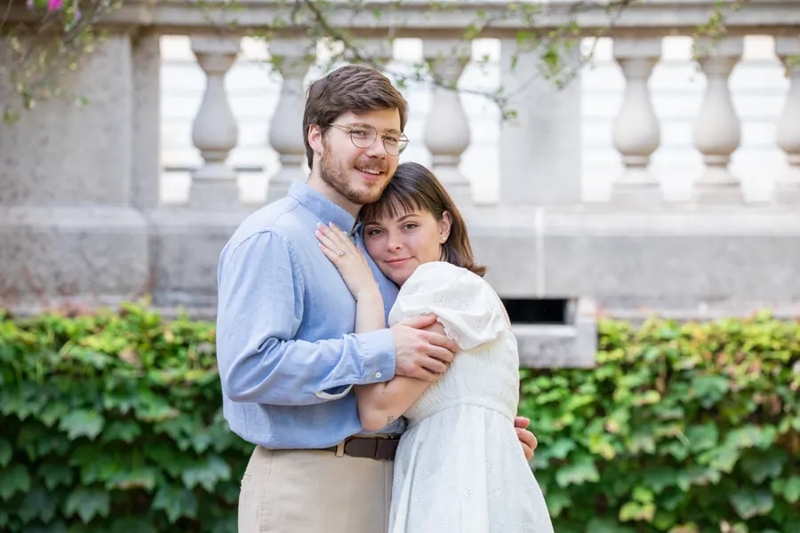 The couple against a stone balustrade and a wall of ivy