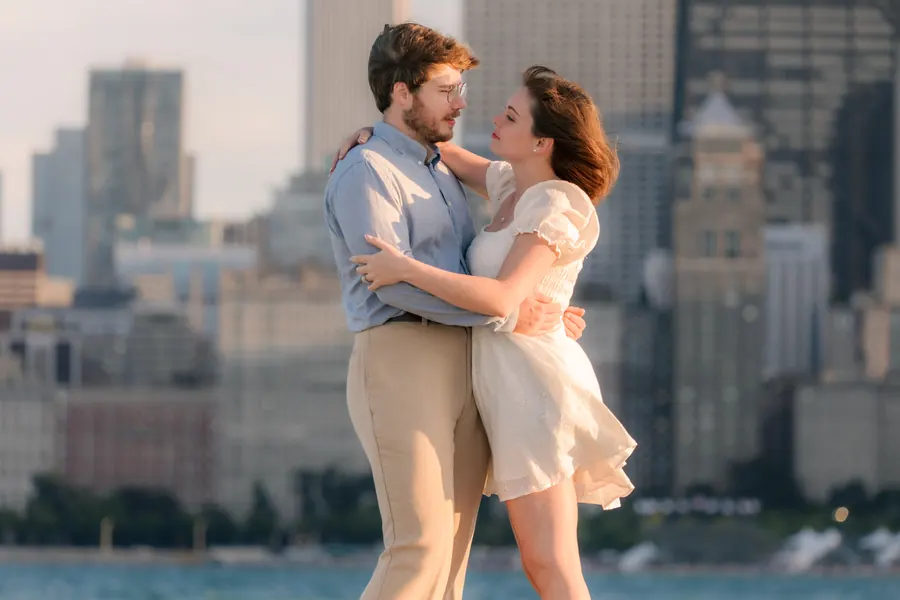 The couple on the lakefront with the city skyline behind them