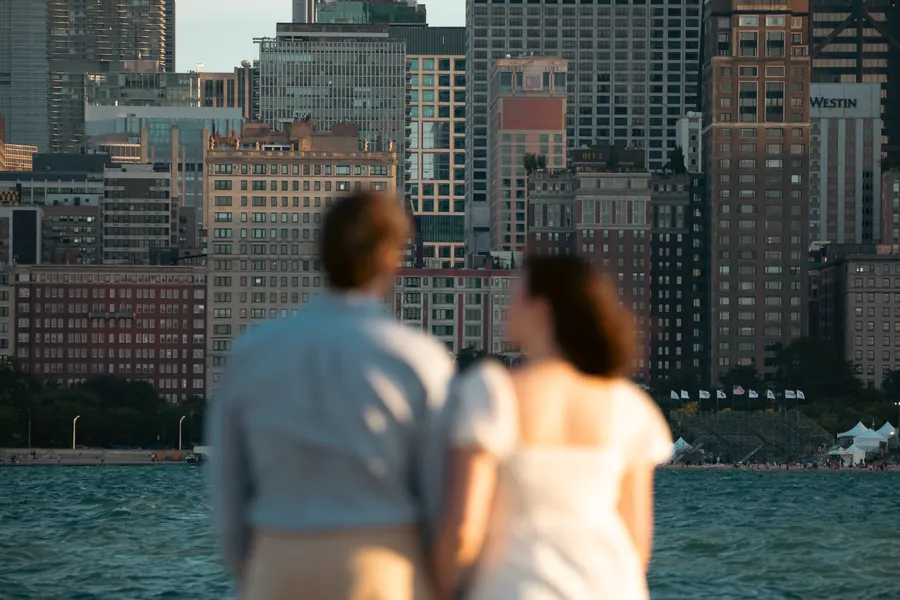 The couple seen from behind looking across the water at the city
