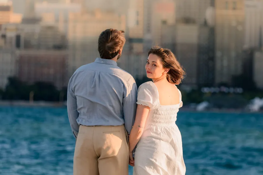 The two of them by the water, turning back toward each other