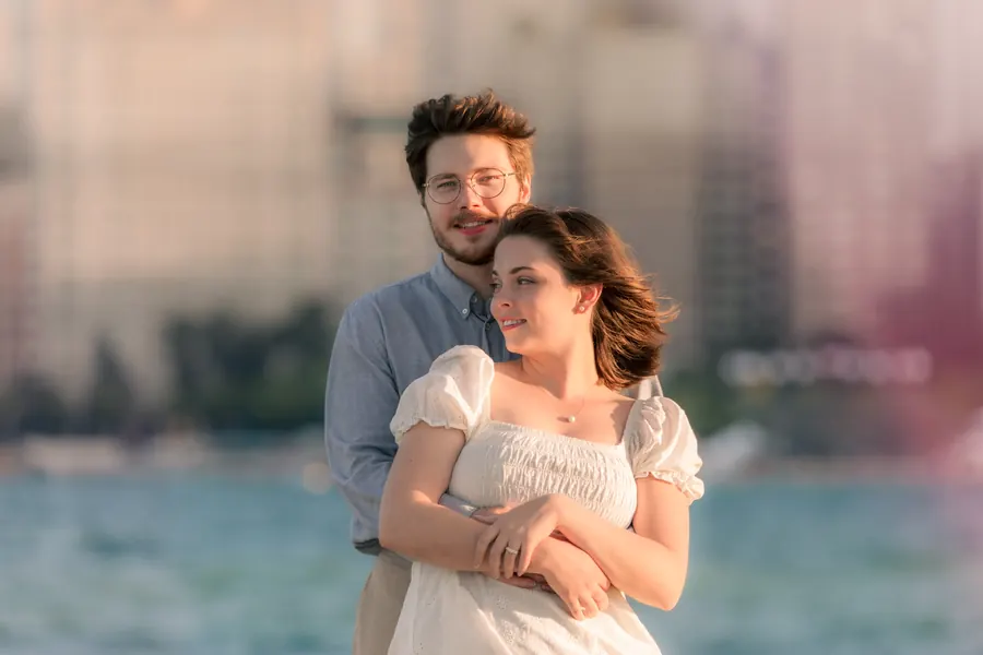 The two of them with the city behind them in pink evening light