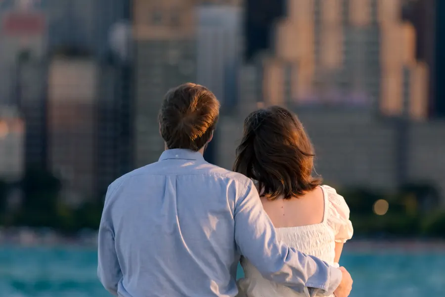 The couple from behind, close together, the skyline soft behind them